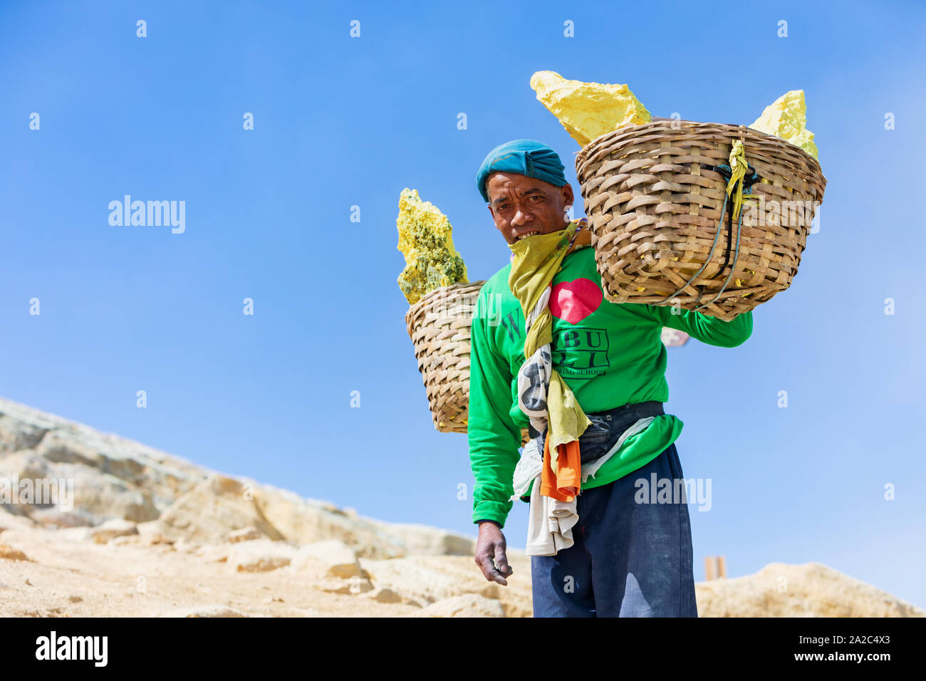 L'île de Java, Indonésie - 16 septembre 2019 : panier avec des morceaux de soufre naturel exerçant miner les épaules de Mine crater de main-d'oeuvre manuelle Banque D'Images
