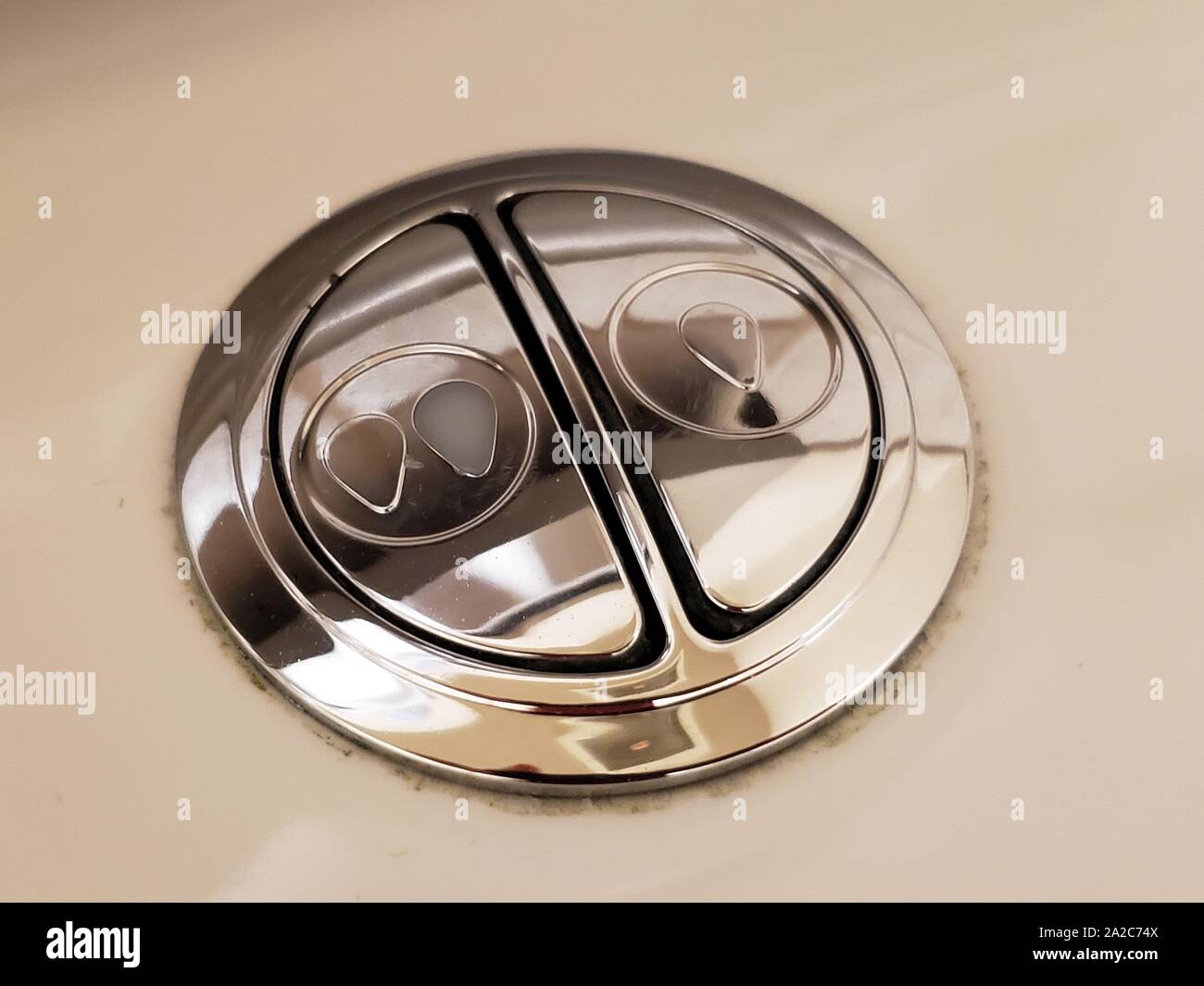 Gros plan des boutons d'un système de toilettes à double rinçage, utilisé pour conserver l'eau en permettant aux utilisateurs de sélectionner deux niveaux différents de volume de rinçage des toilettes, 2 août 2019. () Banque D'Images