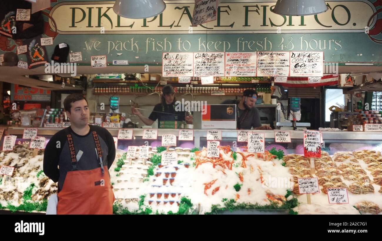 Poissonnier avec combinaisons orange devant la Pike Place Fish Company sur le marché Pike Place à Seattle, Washington, 21 avril 2015. () Banque D'Images