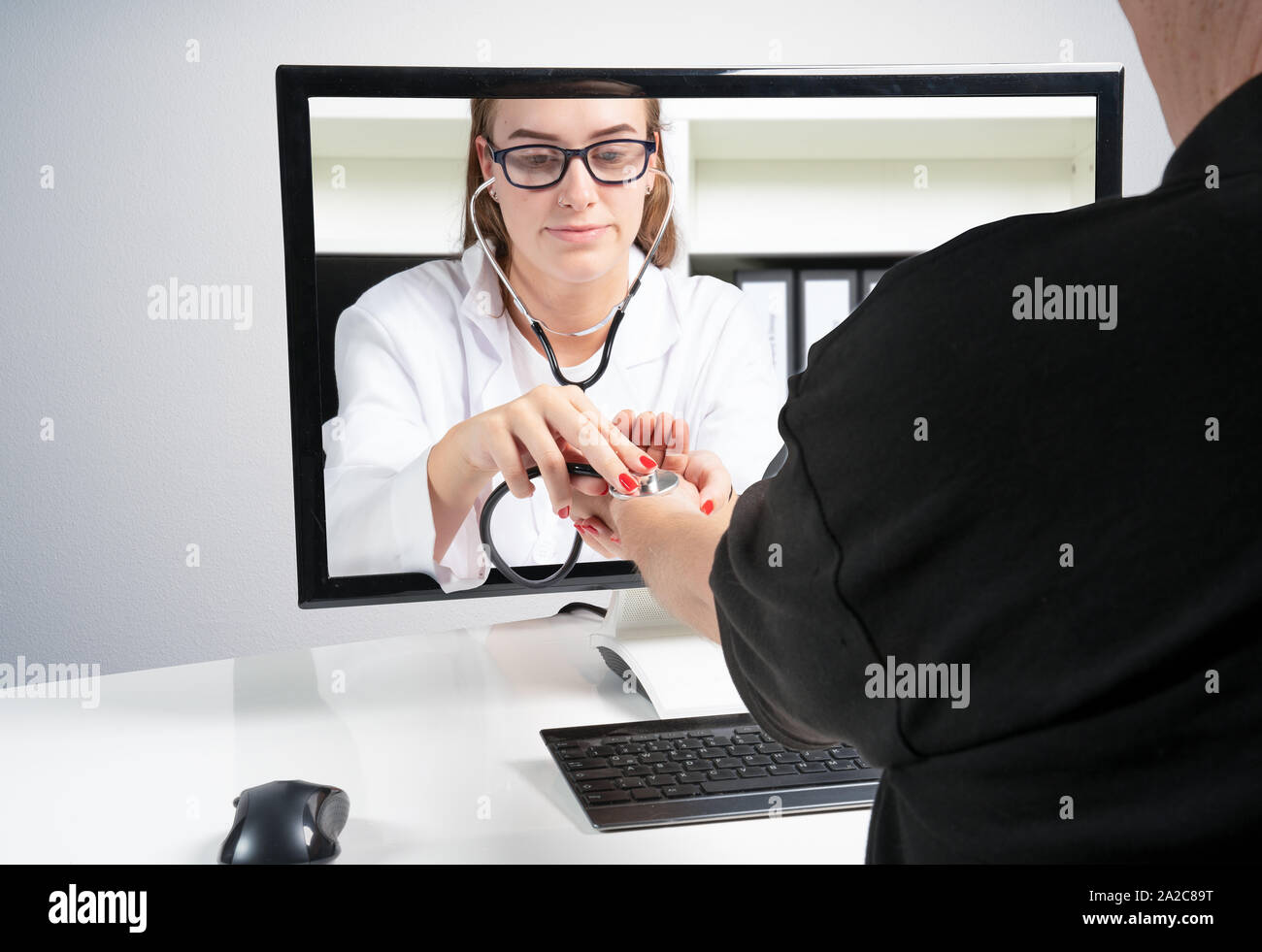 Concept d'examens médicaux à distance. Un médecin fait un examen à distance sur le domicile du patient via le moniteur Banque D'Images