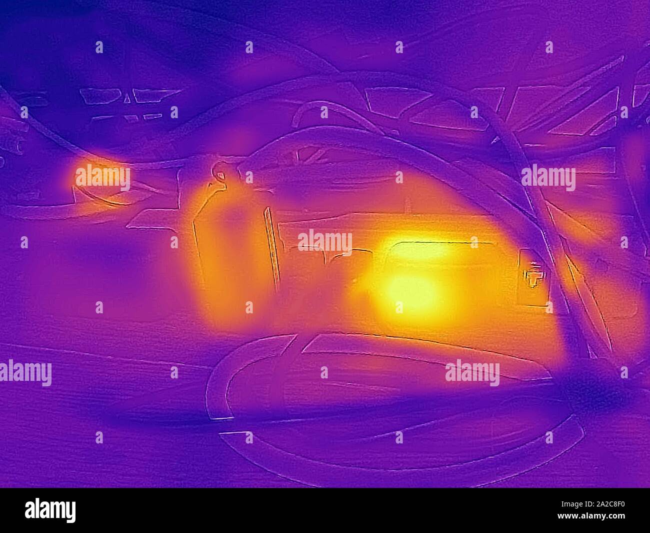 Image thermographique de caméra thermique, avec zones lumineuses correspondant à des températures plus élevées, montrant la chaleur résiduelle générée par les adaptateurs d'alimentation CA connectés à une barrette de connexion, un exemple de charge fantôme ou de perte d'alimentation de secours, appelé colloque sur la puissance vampire ou la charge fantôme, San Ramon, Californie, septembre 2019. () Banque D'Images
