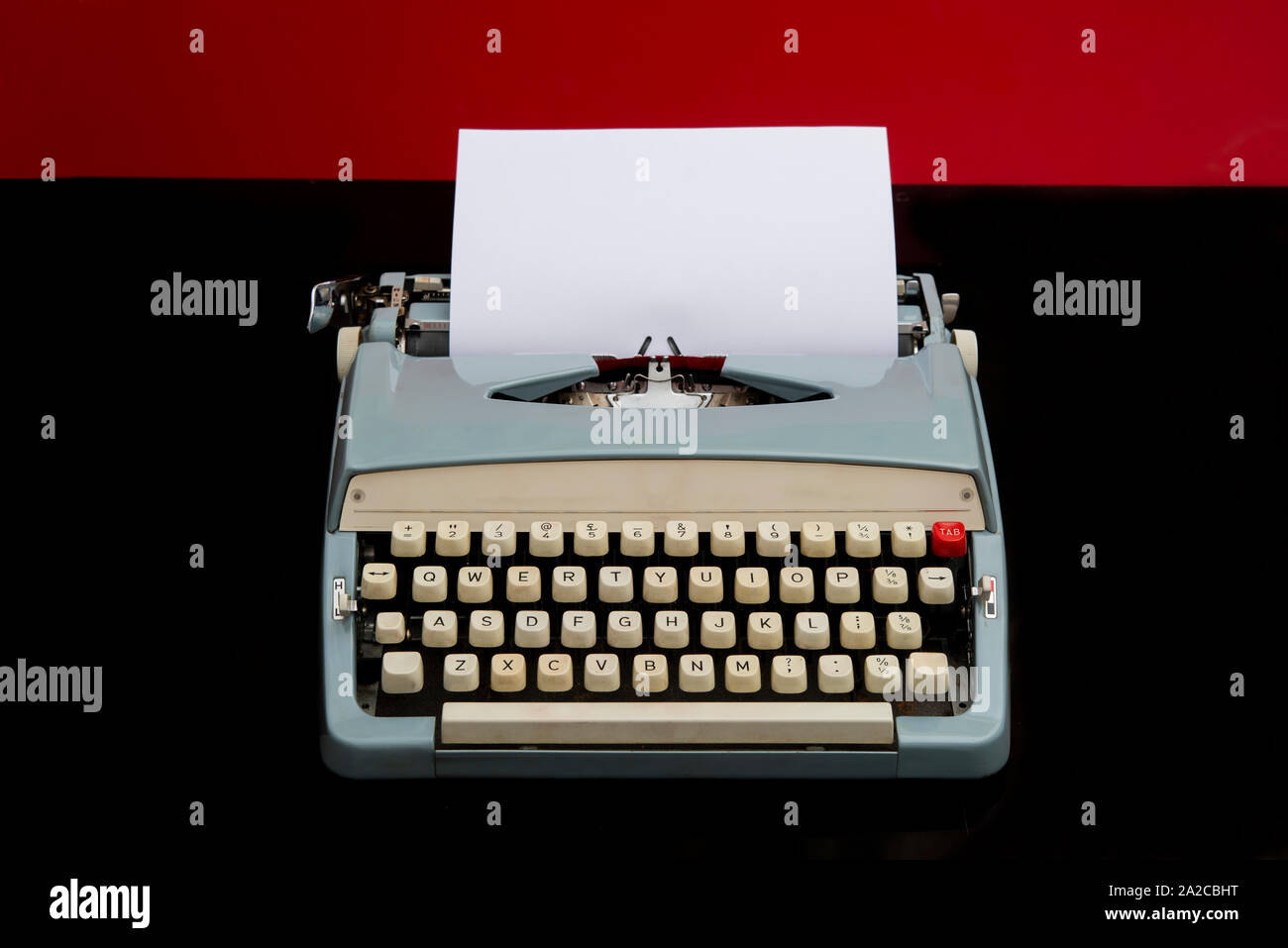 Machine à écrire manuelle avec blank livre blanc sur fond rouge et noir Banque D'Images