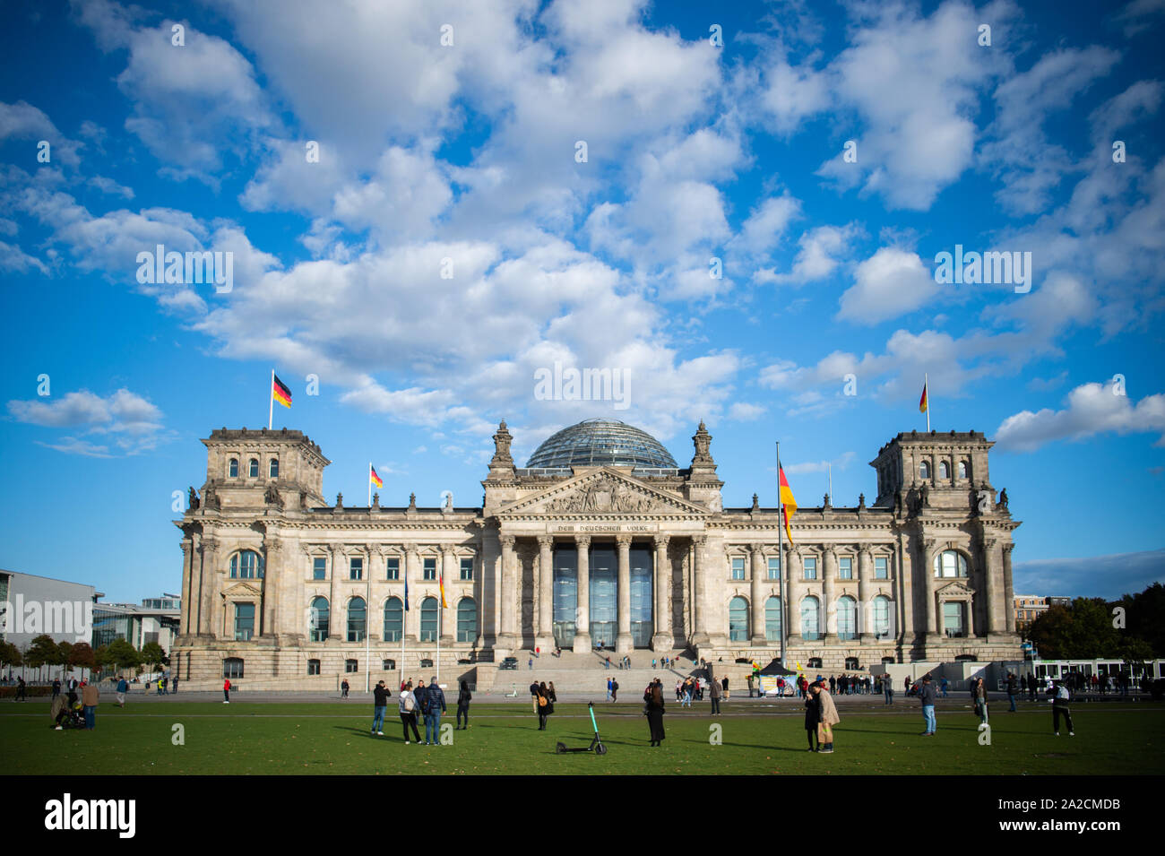 Berlin, Allemagne. 09Th Oct, 2019. Les gens sont debout sur la prairie en face du bâtiment du Reichstag. Credit : Arne Immanuel Bänsch/dpa/Alamy Live News Banque D'Images
