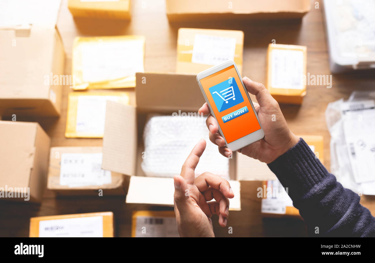Magasinage en ligne concepts avec youngman using smartphone pour le paiement de sa commande sur un lot de produit paquet fort.e-Commerce de détail d'affaires marché..modern Banque D'Images