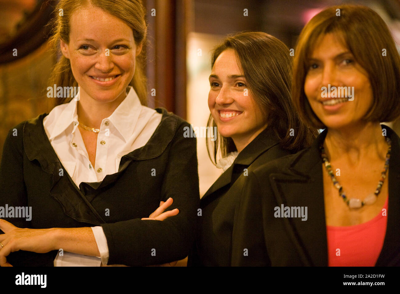 Smiling business woman folding ses bras alors qu'il se tenait à côté de deux collègues de sexe féminin dans un restaurant. Banque D'Images