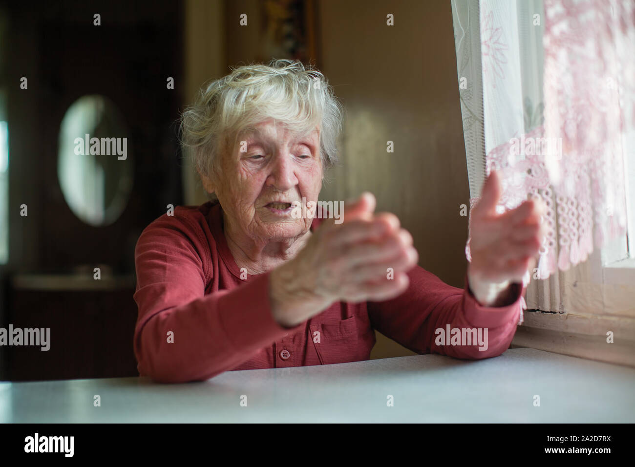 Une femme âgée réagit émotivement en racontant et gesticulant. Banque D'Images