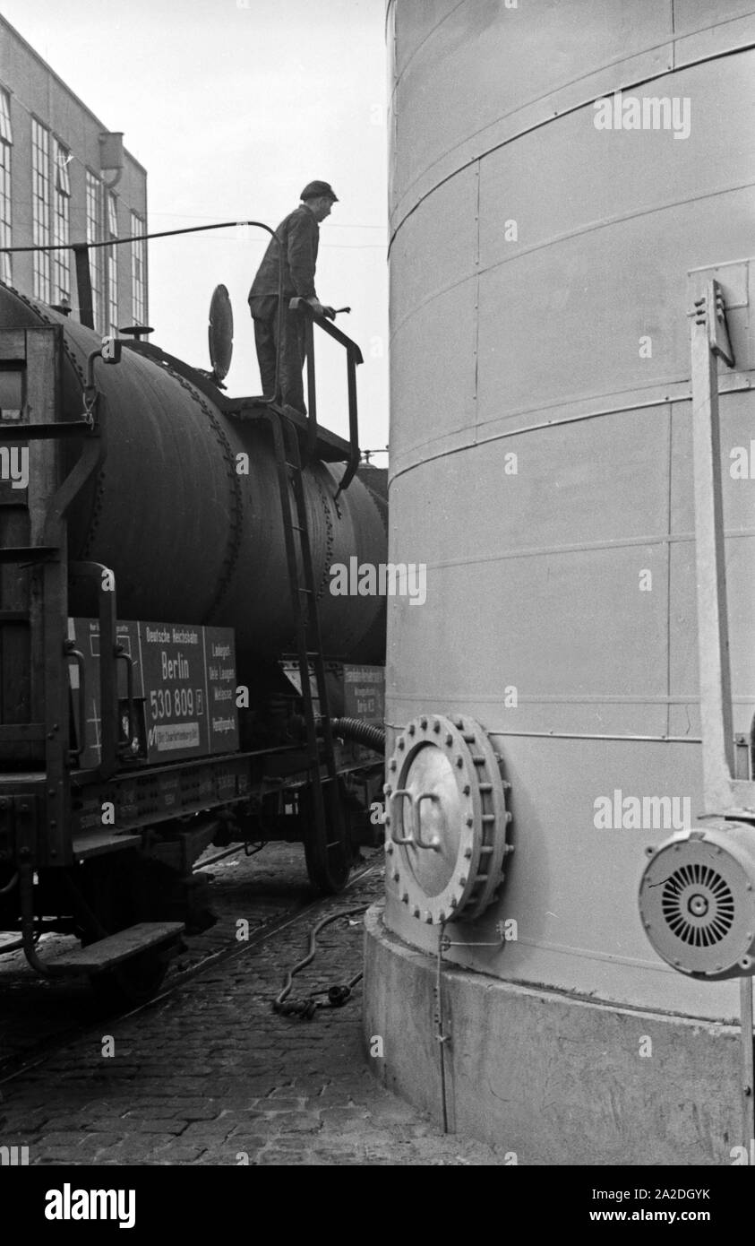 Entlädt Kesselwagen Mitarbeiter Ein auf der auf dem Werksbahn Fettsäurewerke Firmengelände der Deutschen und Märkischen Seifenindustrie à Witten, Deutschland 1930 er Jahre. Membre du personnel du déchargement d'un chaudron de l'usine de wagons de chemin de fer le Fettsäurewerke Seifenindustrie Maerkische Deutsche et compagnie à Witten, Allemagne 1930. Banque D'Images