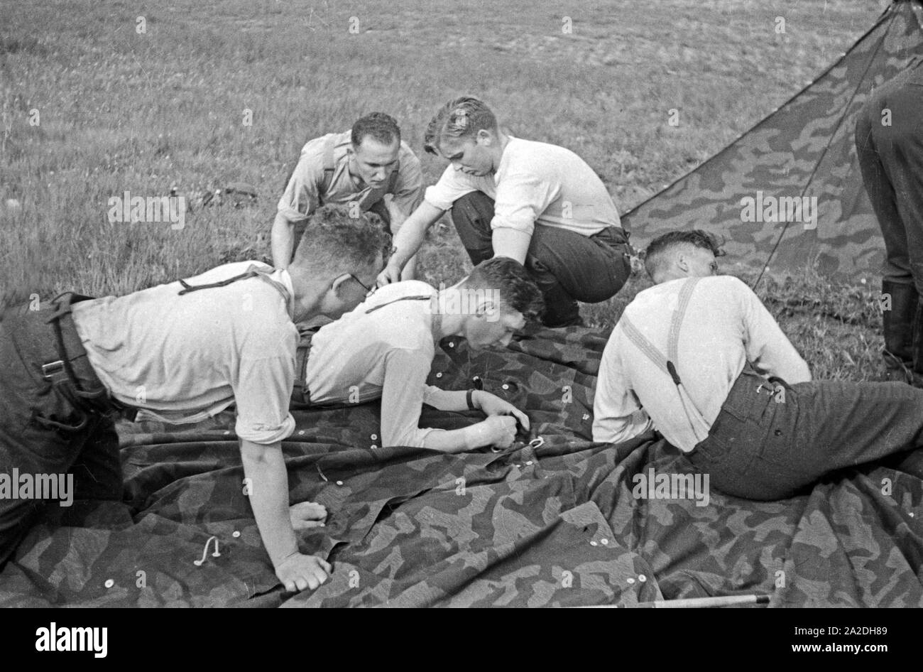 Rekruten der Luftwaffe der Wehrmacht bauen im Rahmen der militärischen Grundausbildung ein Zelt auf, Deutschland 1930 er Jahre. Recrues de la Luftwaffe allemande chargée d'un tente dans leur formation militaire de base, Allemagne 1930. Banque D'Images