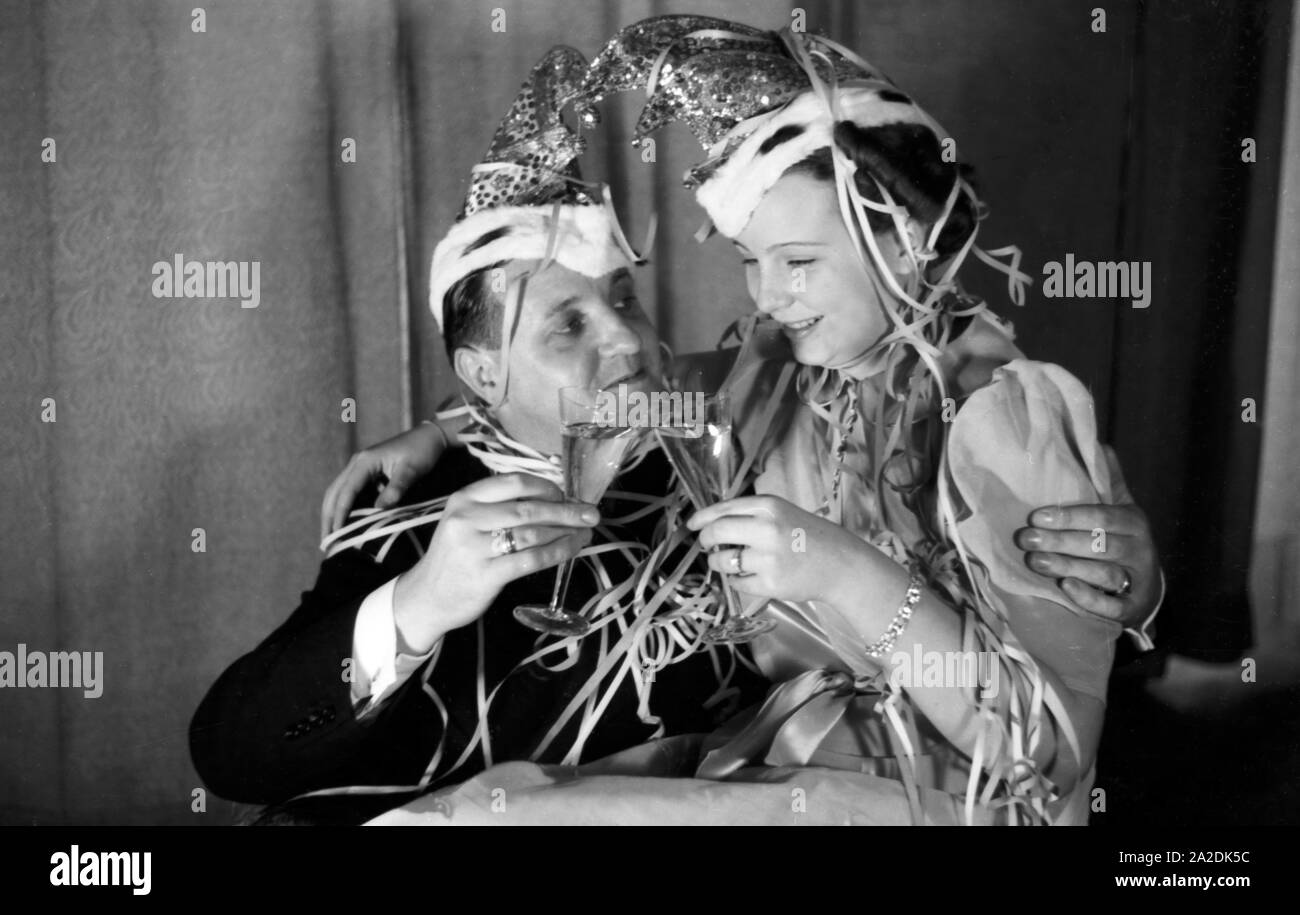 Prinzenpaar das der Fastnacht à Mayence, Martin Ohaus und Hildegard Kühne im Jahre 1938 bei einem Glas Sekt, Abendempfang auf einem zum hundertjährigen Jubiläum des Mainzer Carneval Verein (MCV). Les Altesses Royales de carnaval à Mayence en 1938, à l'occasion du 100e anniversaire de l'association carnaval locales leader, buvant un verre de vin mousseux. Banque D'Images