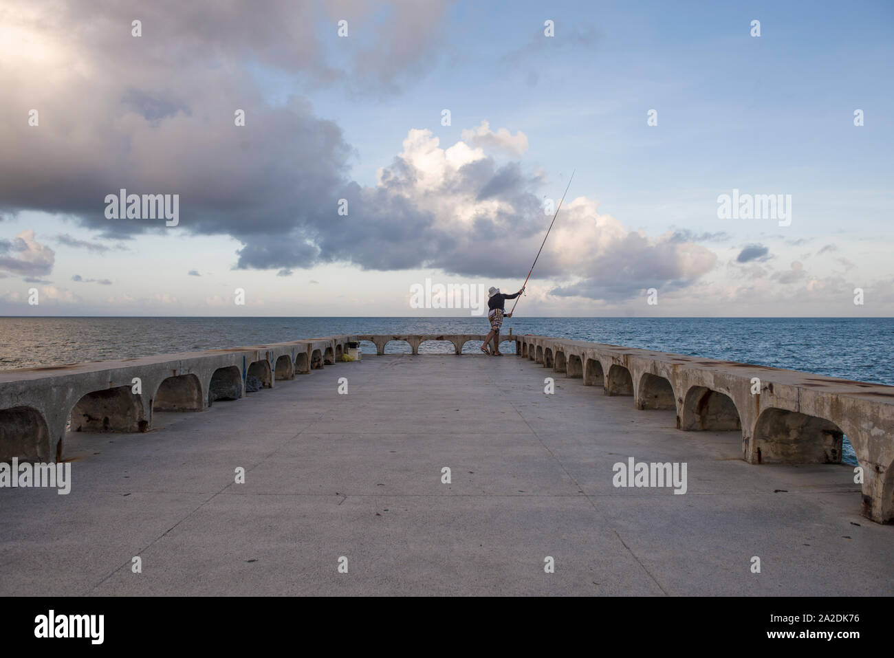 L'homme jette ligne de canne à pêche pour la mer à Olinda pier Banque D'Images