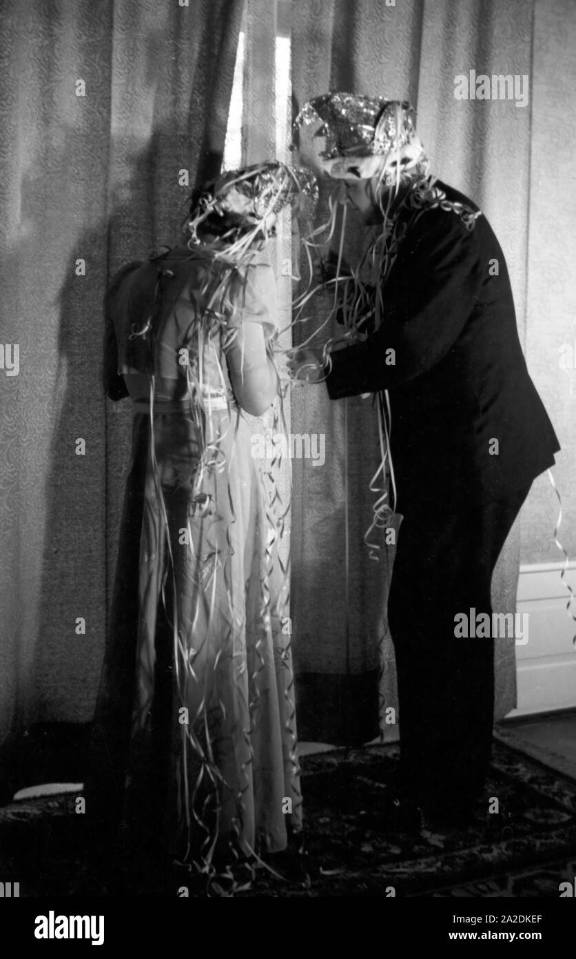 Prinzenpaar das der Fastnacht à Mayence, Martin Ohaus und Hildegard Kühne im Jahre 1938 riskiert einen Blick durch einen Vorhang, zum hundertjährigen Jubiläum des Mainzer Carneval Verein (MCV). Les Altesses Royales de carnaval à Mayence en 1938, à l'occasion du 100e anniversaire de l'association carnaval locales leader, avoir un regard à travers un rideau. Banque D'Images