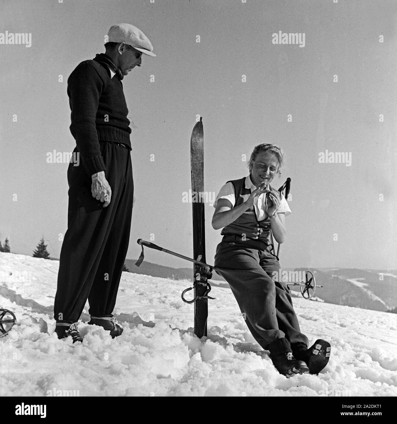Zwei Skiläufer bei einer Unterhaltung, Deutschland 1930er Jahre. Deux touristes de ski chat, Allemagne 1930. Banque D'Images