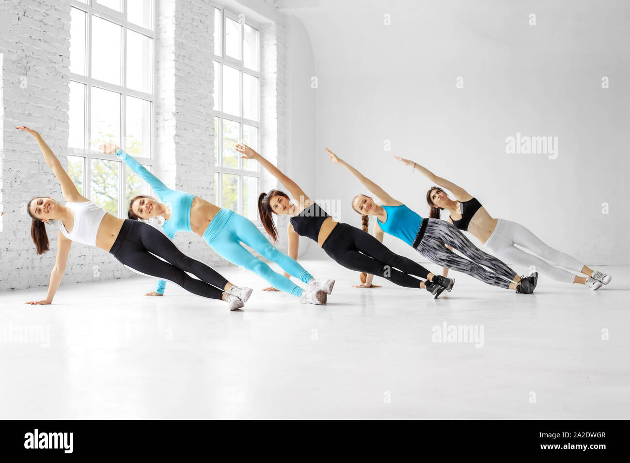 Les jeunes femmes n'aérobic dans la classe de danse. Le concept de sport, un style de vie sain, fitness, stretching et danse. Banque D'Images