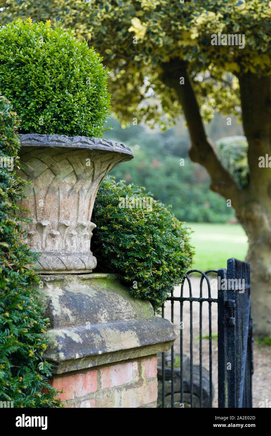 Jardin anglais avec une urne en pierre de style victorien. Angleterre, Royaume-Uni Banque D'Images