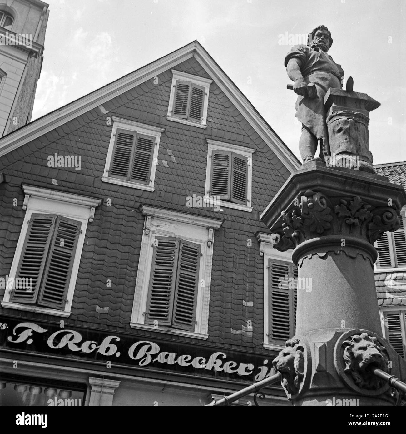 Denkmal des tapferen Schmieds Peter Hahn vor dem Modehaus Baecker auf dem Alten Markt à Solingen, Allemagne Allemagne Années 1930 er Jahre. Monument des braves blacksmith Peter Hahn en face de fashion store Baecker au vieux marché principal à Solingen, Allemagne 1930. Banque D'Images