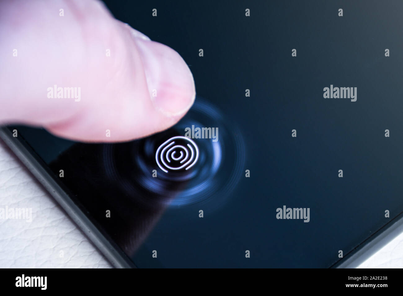 Déverrouillage du téléphone avec le doigt sur un scanner d'empreintes digitales numériques construit dans le cadre de l'écran qui vous intéresse Banque D'Images
