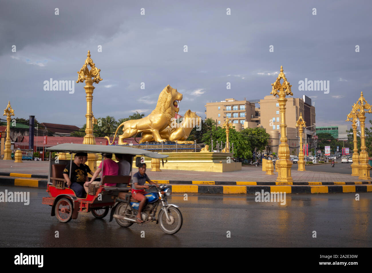 Un tuktuk en passant devant des statues de lion à Sihanoukville Banque D'Images