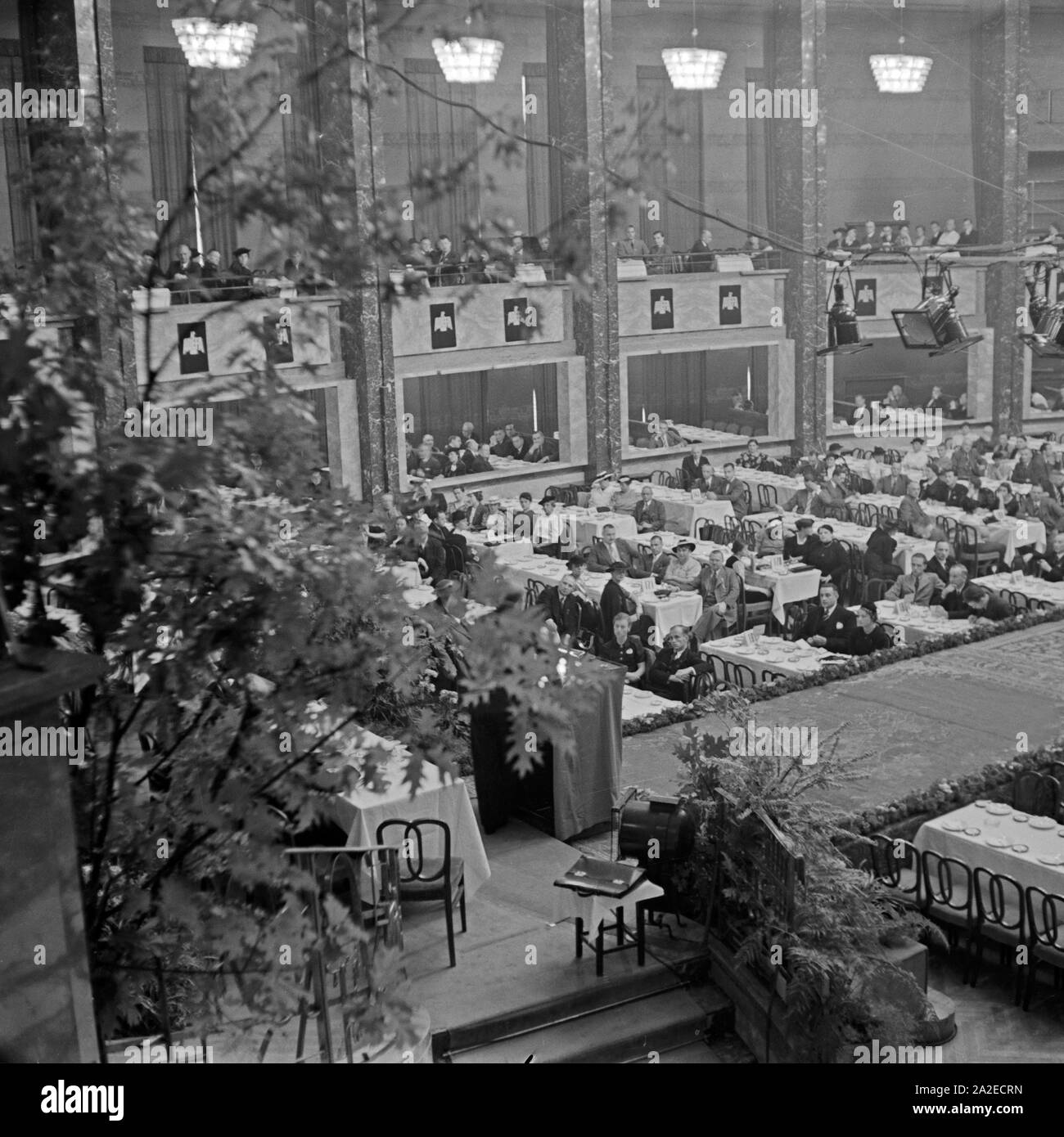 Langsam füllt sich die Halle mit Gästen für die ADEFA Modenschau, Deutschland 1930 er Jahre. Guest avant le début de l'ADEFA fashion show, Allemagne 1930. Banque D'Images