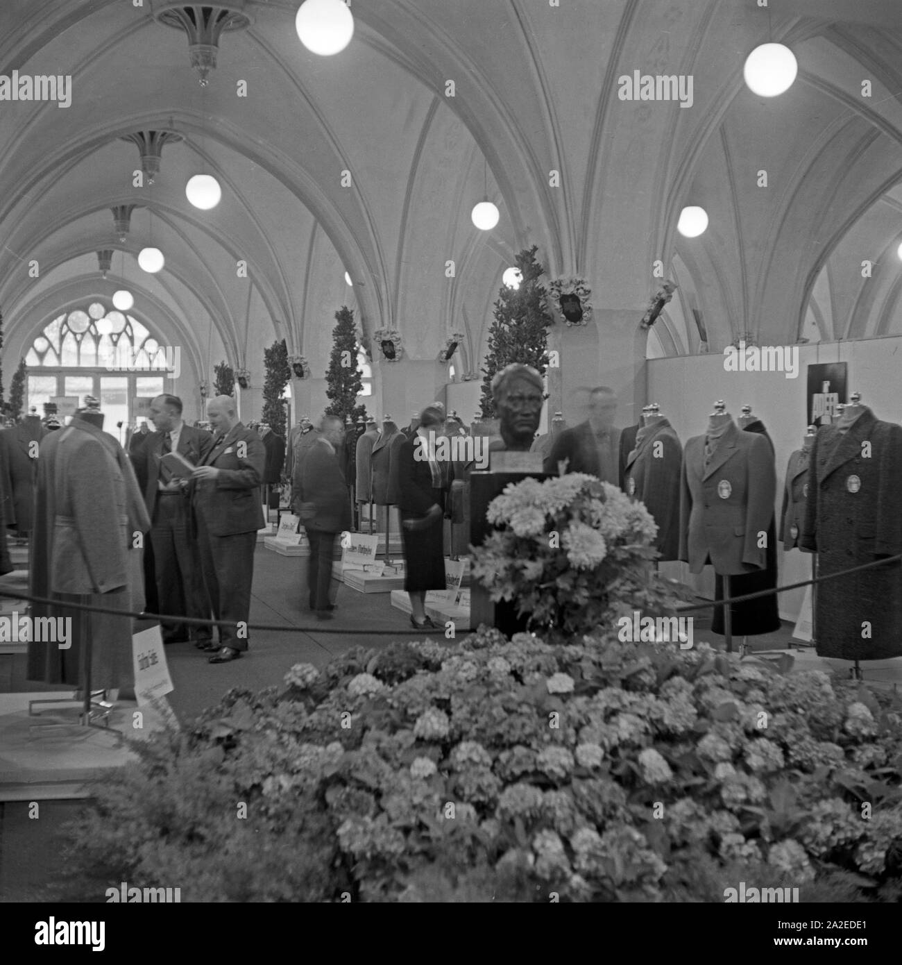 Einkäufer Besucher und sehen sich die Ausstellung im Rahmen der ADEFA un Modenschau, Deutschland 1930 er Jahre. Les responsables d'achats et les visiteurs se promenant dans l'exposition à l'ADEFA fashion show, Allemagne 1930. Banque D'Images