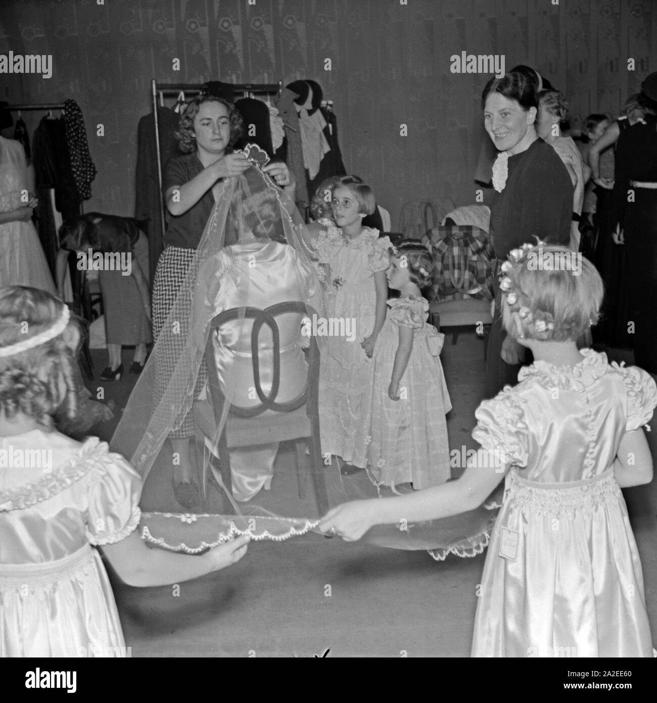 Blumenkinder und die Braut für den Brautmoden Teil der ADEFA Modenschau werden, feriggemacht Deutschland 1930 er Jahre. Enfants et l'épouse en préparation pour la partie de la robes de partie de l'ADEFA, mon premier ensemble trainz show, Allemagne 1930. Banque D'Images