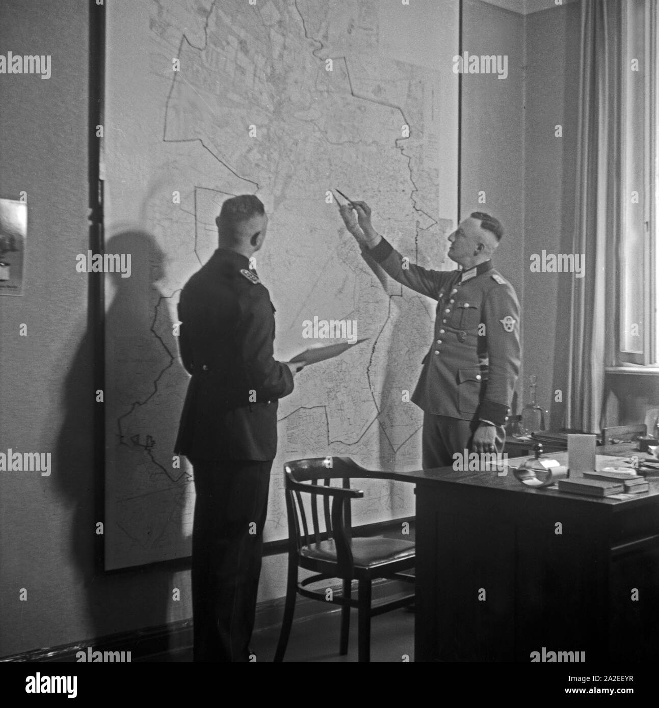 Vor der großen Lagekarte im Büro des Chefs des Unfallkommandos, 1930er Jahre Deutschland. En face de la carte de la ville au bureau du chef de l'Verkehrsunfallkommando, Allemagne 1930. Banque D'Images