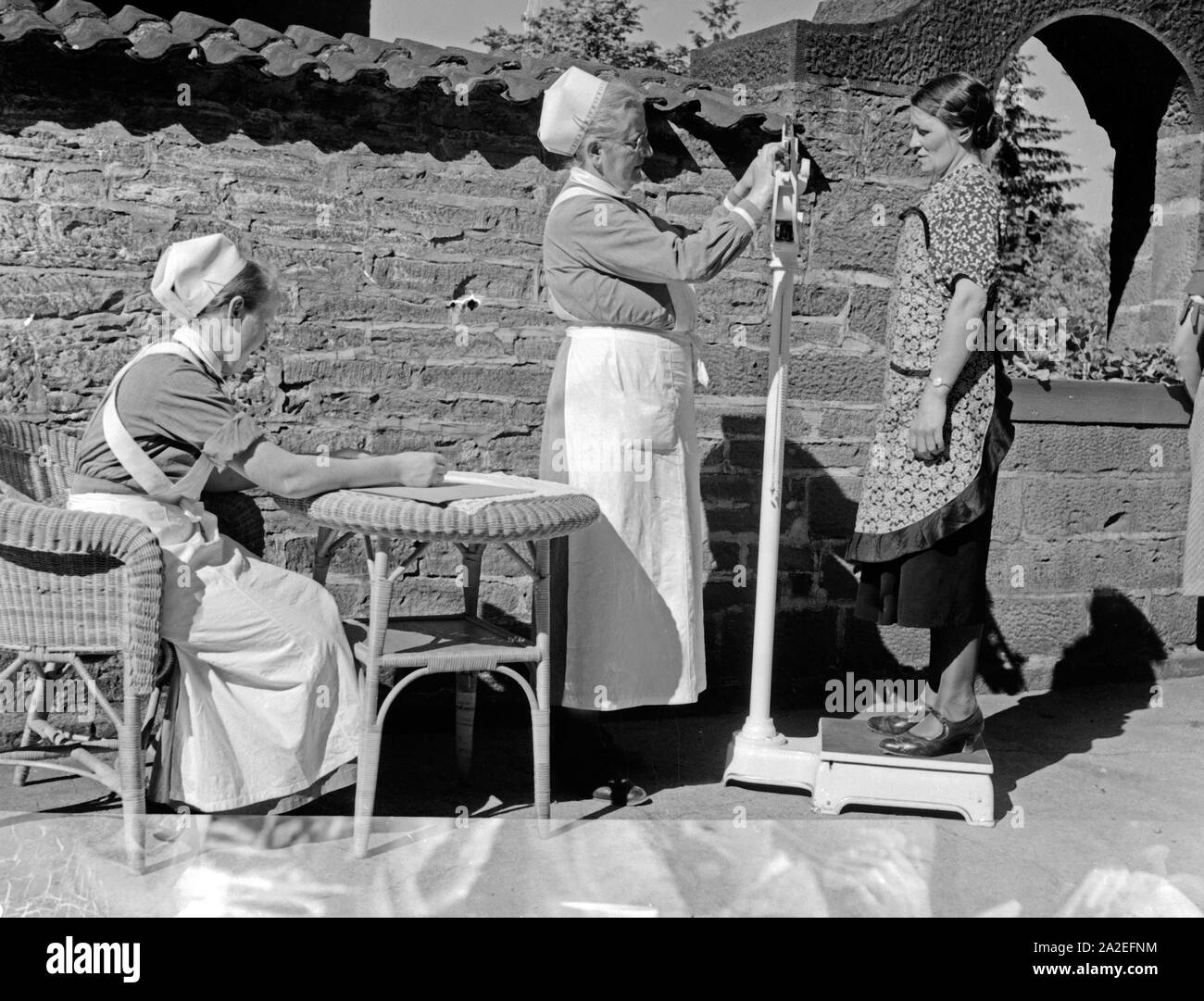 Krankenschwestern Gewichtskontrolle Patientin mit der Mutter und im Genre Heim dans Tabarz, Thüringer Wald, 1930er Jahre. La vérification du poids des infirmières et infirmiers d'une femme à une femme et enfant accueil de loisirs à Vesser, Thuringe, 1930. Banque D'Images