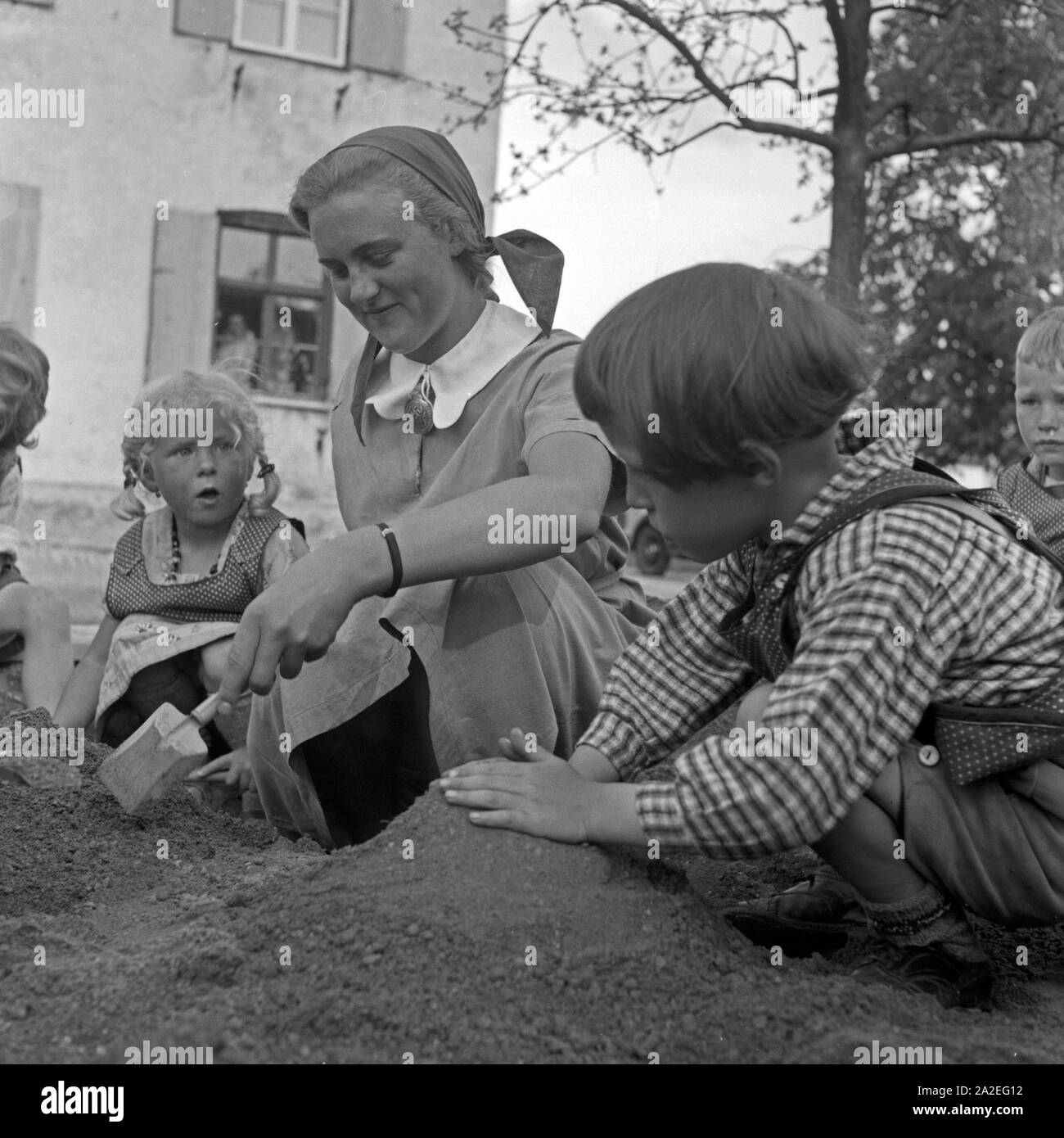 Spielt Eine Frau mit kleinen Kindern beim Frauenarbeitsdienst à Kempten, Deutschland 1930 er Jahre. Une femme jouant avec les tout-petits à la main-d'oeuvre féminine à Kempten, Allemagne 1930. Banque D'Images