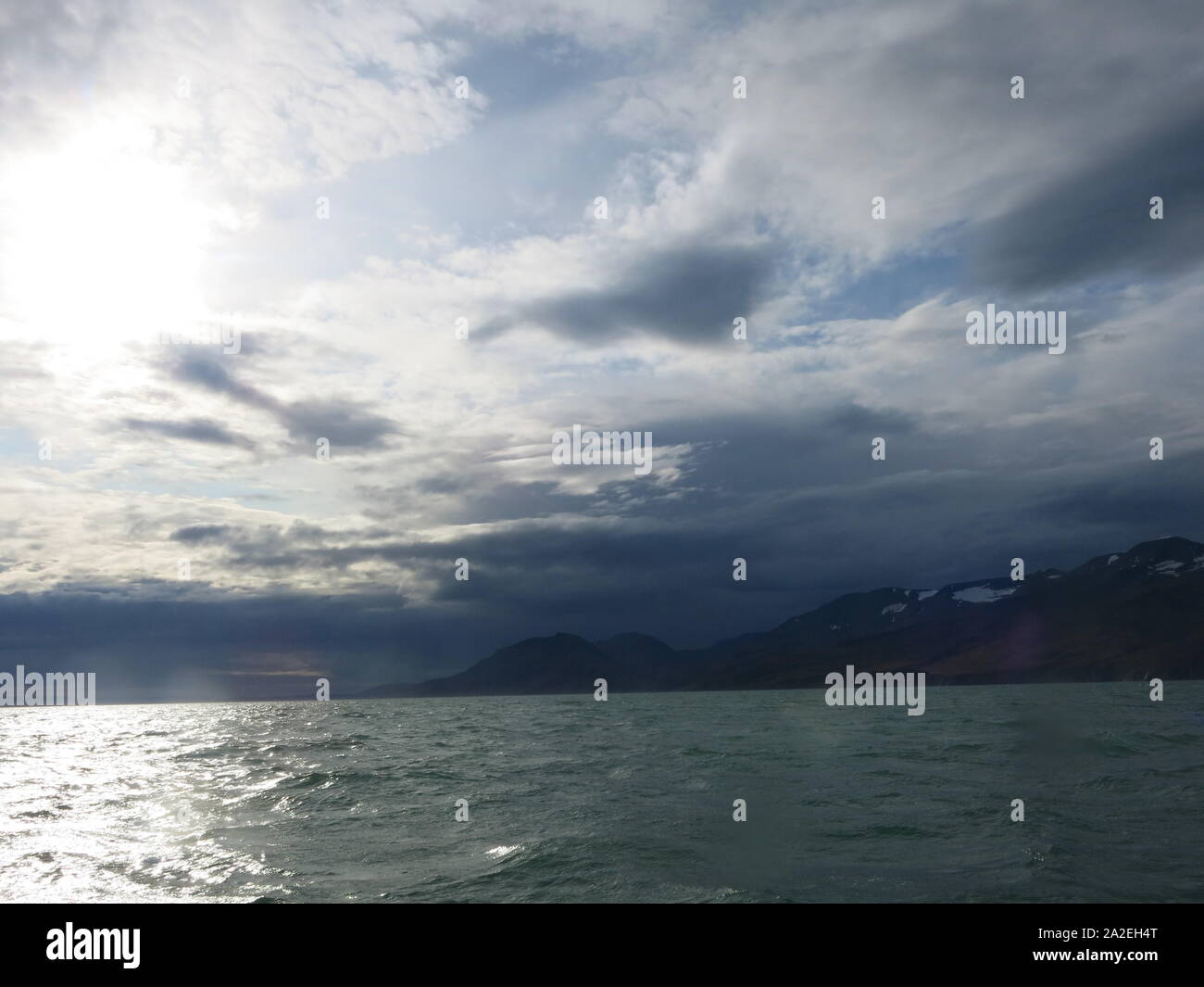 Paysages islandais de vagues agitées et montagnes au loin avec des aperçus de la glace, de Skjalfandi Bay Banque D'Images