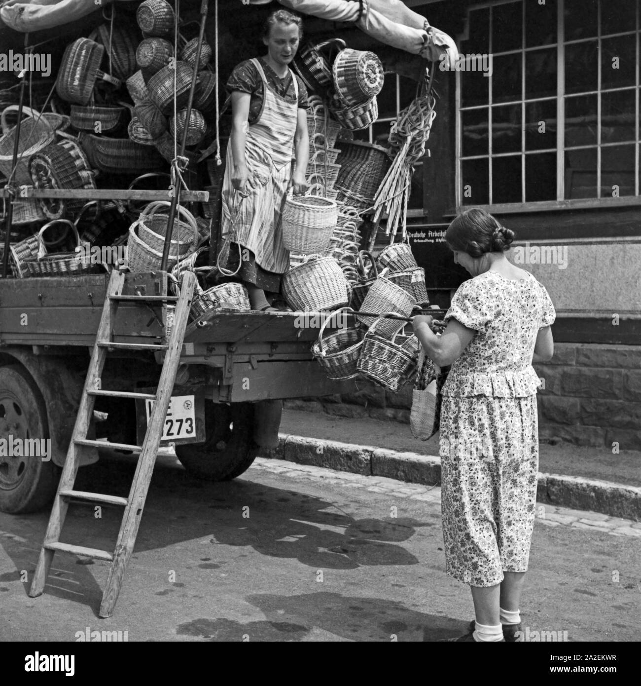 Eine Korbhändlerin verkauft ihre Ware von der Pritsche votre Lieferwagens à Cannstatt, Deutschland 1930er Jahre. Un panier vendeur de vendre ses marchandises directement de sa camionnette pour les clients à Cannstatt, Allemagne 1930. Banque D'Images