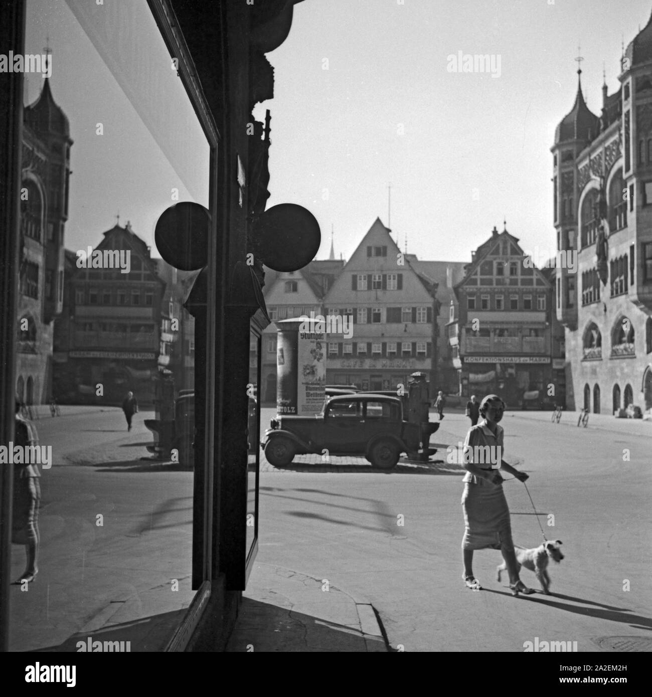 Eine junge Frau mit ihrem Foxterrier spaziert über den Markt à Stuttgart, Deutschland 1930er Jahre. Une jeune femme walkingh son chiot fox terrier sur le marché à Stuttgart, Allemagne 1930. Banque D'Images