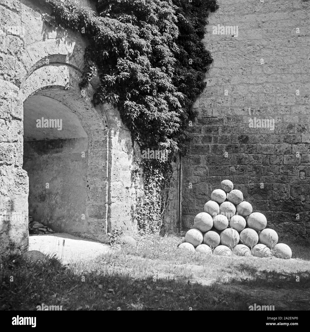 Kanonenkugeln Bechelsdorf Ein alter im Burghof der Burg von Burghausen, Deutschland 1930 er Jahre. Une pile de boulets de pierre dans la cour de l'ancien château de Burghausen, Allemagne 1930. Banque D'Images