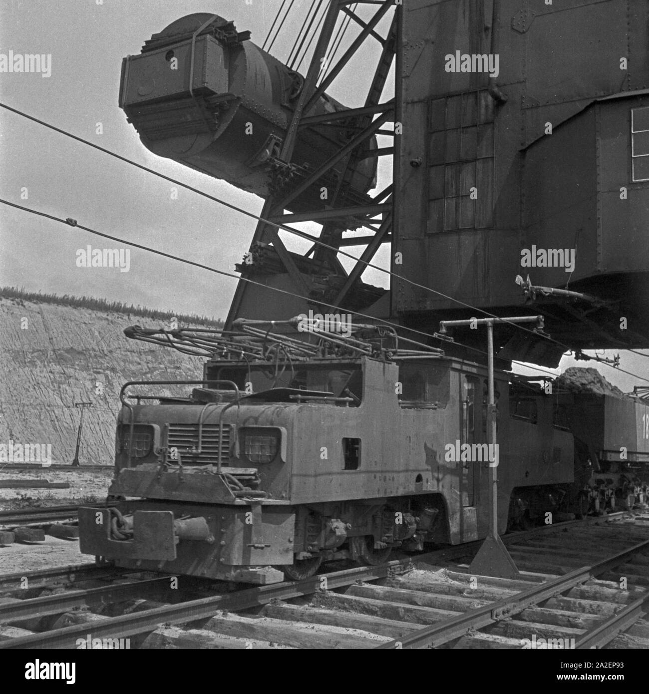 Ein Güterzug, von einer Elektrolokomotive eigenschaften, wird mit einer Ladung Bernstein bei im Palmnicken Samland dans Ostpreußen befüllt, Deutschland 1930 er Jahre. Un train de fret est chargé avec ambre à Palmnicken à Sambia en Prusse orientale, Allemagne 1930 Banque D'Images