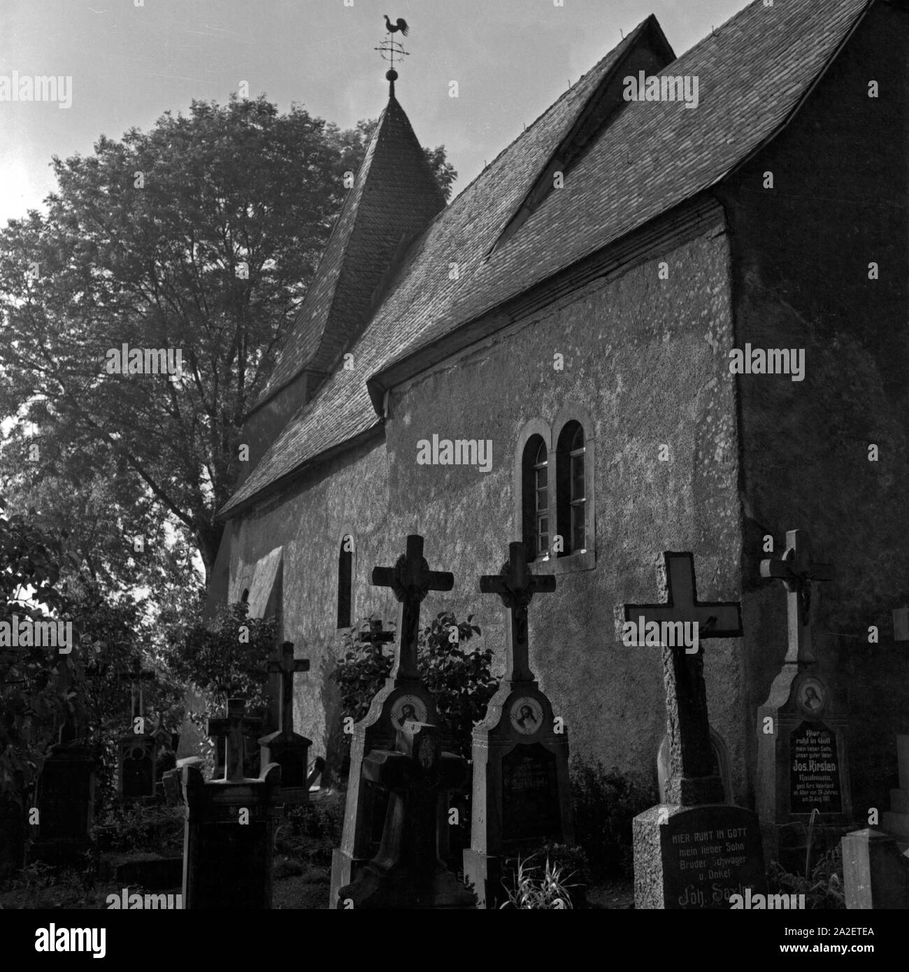 Blick auf die Kirche und den Friedhof Weinfeld bei Daun in der Eifel, Deutschland 1930 er Jahre. Vue de l'église et le cimetière à Weinfeld près de Daun à région de l'Eifel, Allemagne 1930. Banque D'Images