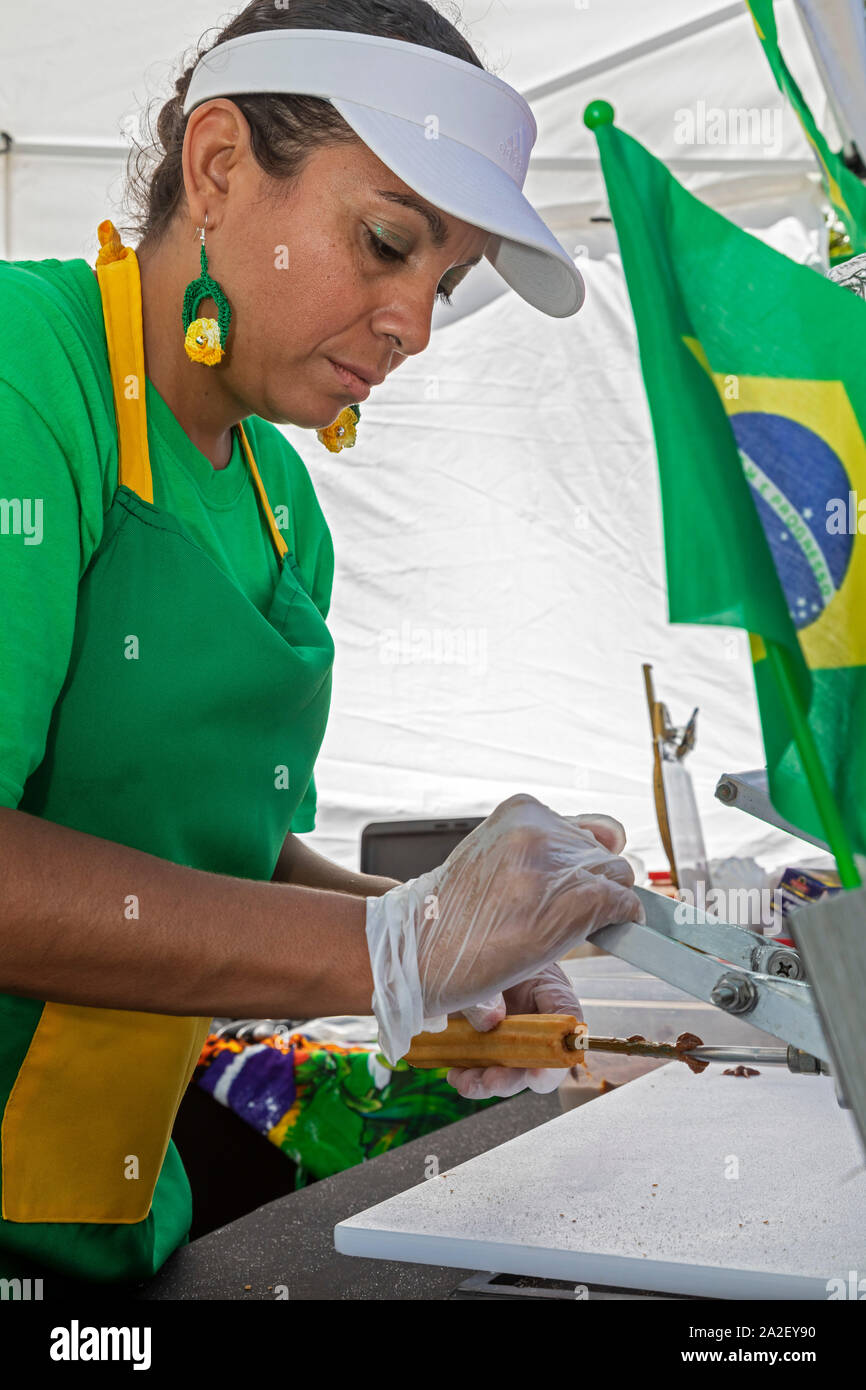 Detroit, Michigan - Le jour annuel festival de rue présente aliments et un concours de danse samba. Un travailleur se remplit, un churros pâte feuilletée-frites. Banque D'Images