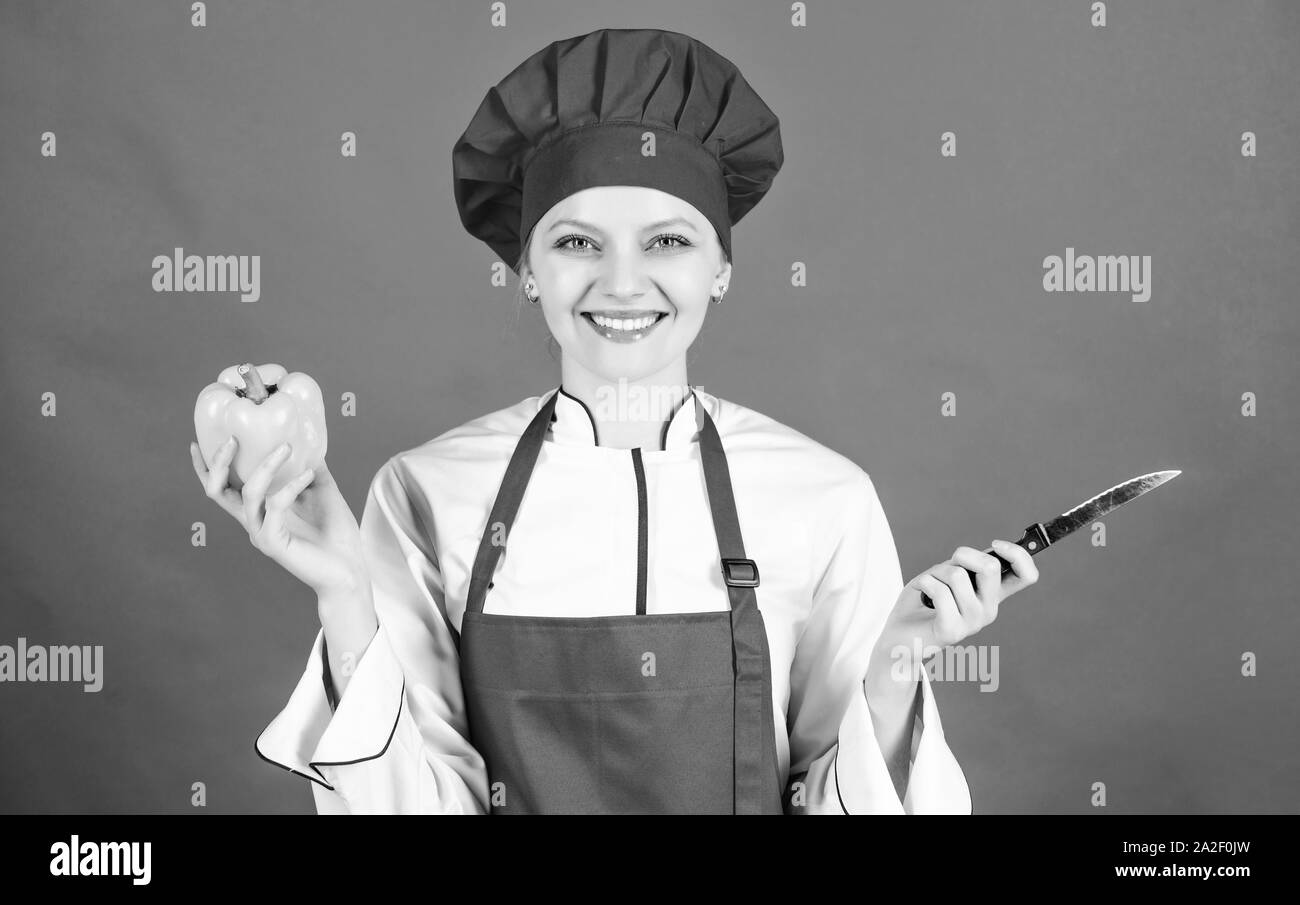 Woman in hat cook et tablier. chef professionnel en cuisine. Cuisine. Femme au foyer avec des plaques de couteau. happy woman la cuisson des aliments sains par recette. sweet pe Banque D'Images