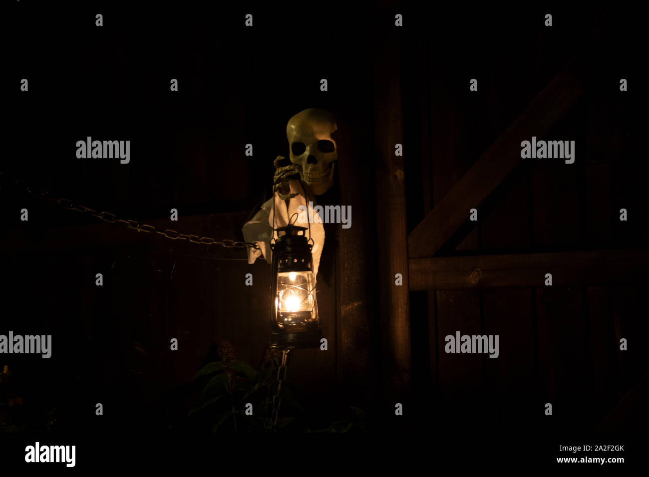 Droitwich Spa, Worcester, England, United Kingdom, 02/10/2019, Ghost tours, squelette tenant une lampe à huile allumée contre une structure en bois dans la nuit. Hallo Banque D'Images