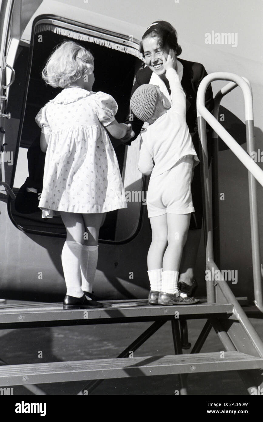 Hôtesse de l'hilft bei der die Ankunft / Adoption / beim chargé / Austieg aus dem Flugzeug, Deutschland 1930er Jahre. Hôtesse de l'aide aux enfants d'arriver / Départ / saisie / quitter un avion, Allemagne 1930. Banque D'Images