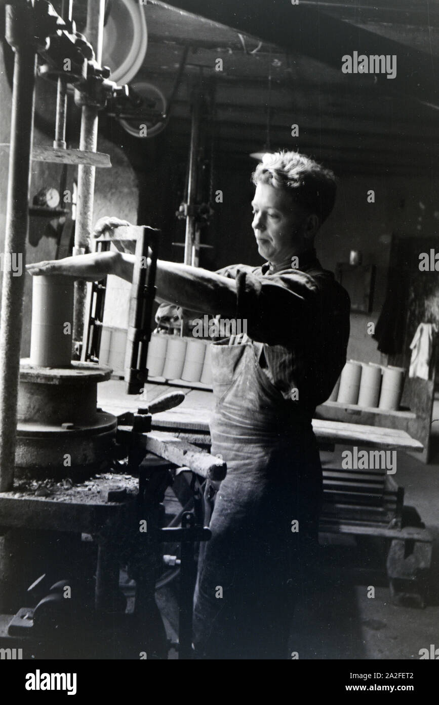 Ein Mitarbeiter einer Steinzeug Fabrik im Kannenbäckerland schneidet rohen tonne zurecht, Deutschland 1930 er Jahre. Un employé d'une usine de grès dans l'argile brute Kannenbäckerland est couper en morceaux plus petits, Allemagne 1930. Banque D'Images