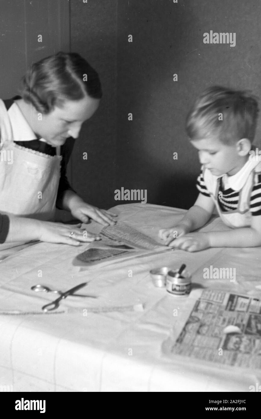 Mutter und genre beim basteln, Deutschland 1930 er Jahre. La mère et l'enfant de faire de l'artisanat, de l'Allemagne des années 1930. Banque D'Images