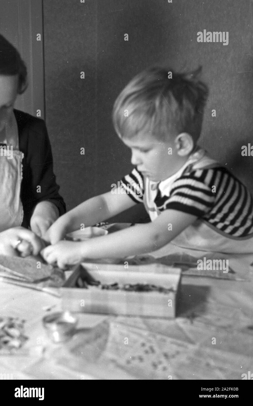 Mutter und genre beim basteln, Deutschland 1930 er Jahre. La mère et l'enfant de faire de l'artisanat, de l'Allemagne des années 1930. Banque D'Images