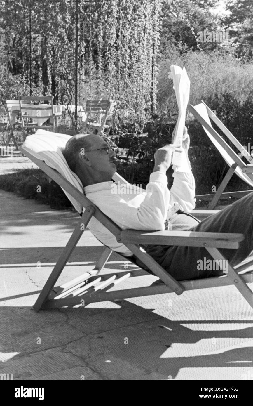 Ein Mann liest die Zietung im Urlaub an der Ostsee, Deutschland 1930 er Jahre. Un homme tge readin journal sur ses vacances sur la mer Baltique, Allemagne 1930. Banque D'Images