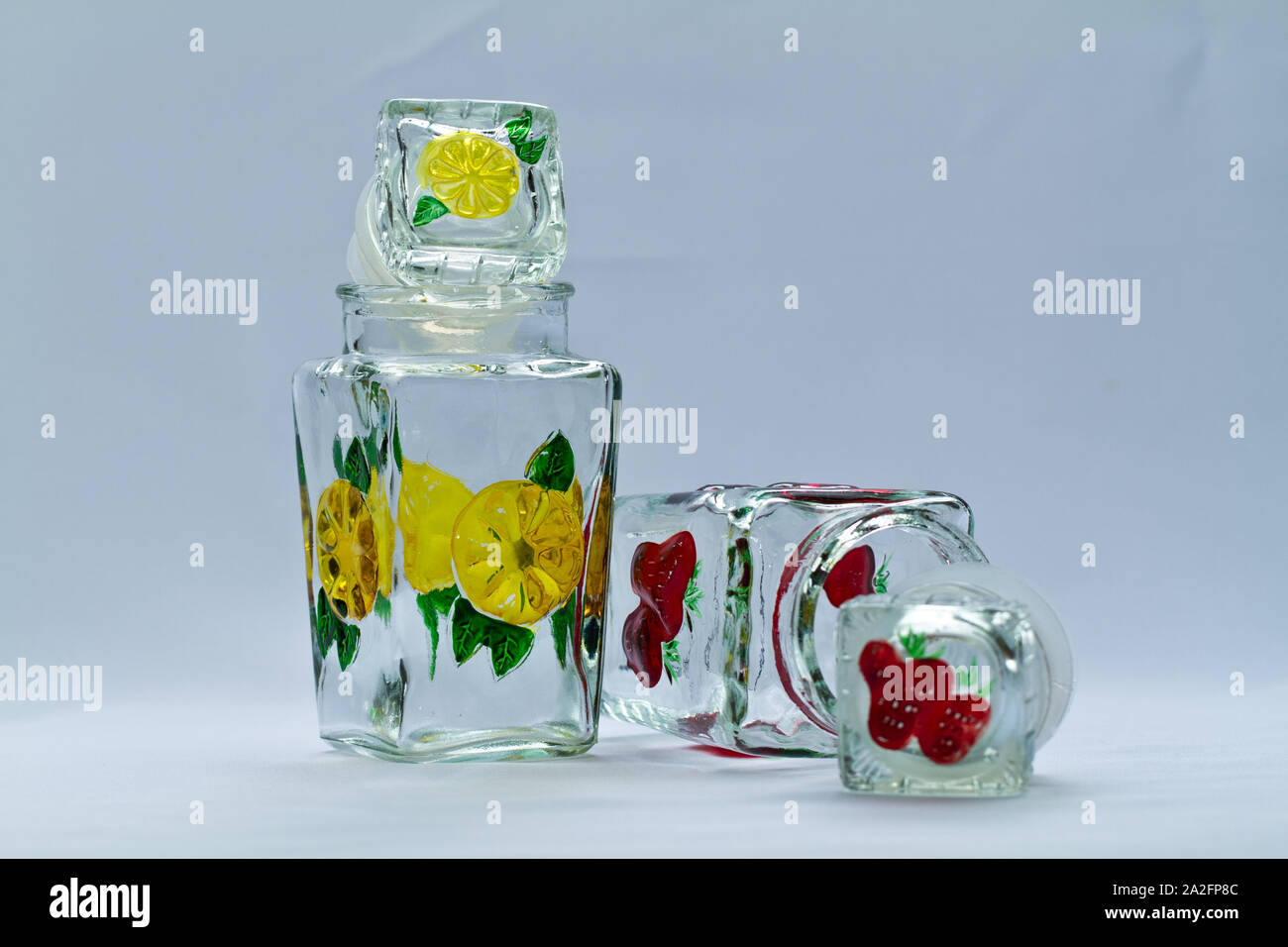 Motifs de fleurs contenant en verre avec couvercle sur fond blanc Banque D'Images