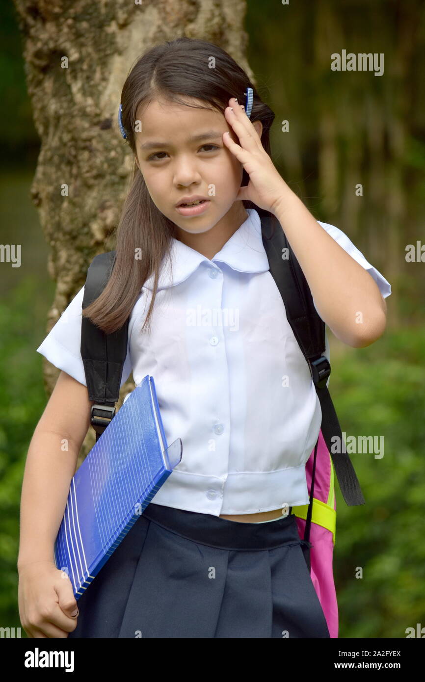 L'École réfléchie Girl Wearing School Uniform avec Books Banque D'Images