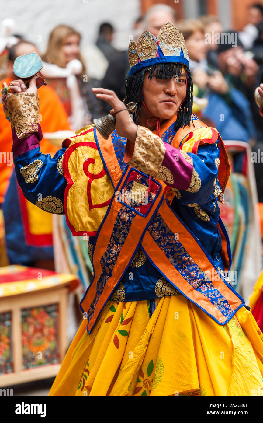Bumthang, Bhoutan, 06 Novembre 2011 : interprète la danse de costumes colorés au festival à Jakar Dzong tout en tenant la main de cérémonie bell. Banque D'Images