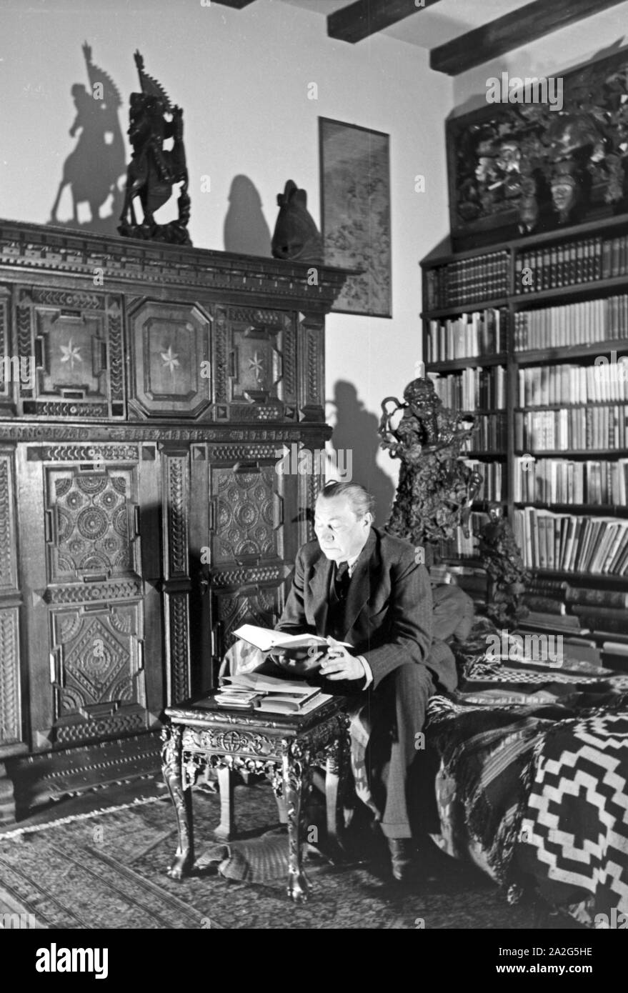 Acteurs et Actrices Der Deutsche Paul Wegener sitzt zu Hause und Bibliothek senneur dans eine raucht Zigarre à Berlin, Deutschland 1930er Jahre. L'acteur allemand Paul Wegener fumer un cigare tout en restant assis dans la bibliothèque de sa maison à Berlin, Allemagne, 1930. Banque D'Images