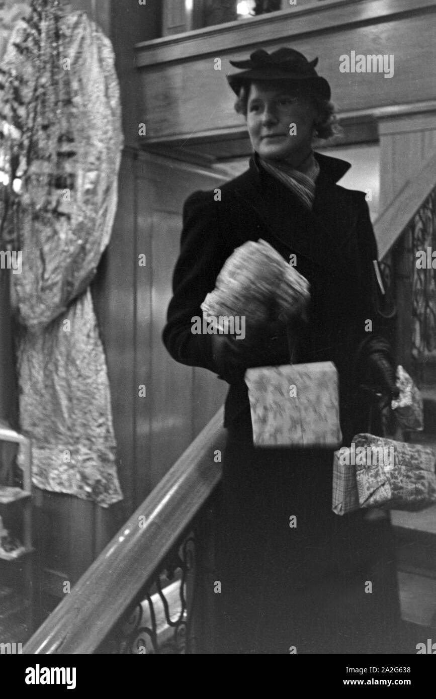 Eine Frau bei einem dans Weihnachtseinkäufen Kaufhaus, Deutschland 1930 er Jahre. Une femme faire son shopping de Noël dans un departement store, Allemagne 1930. Banque D'Images