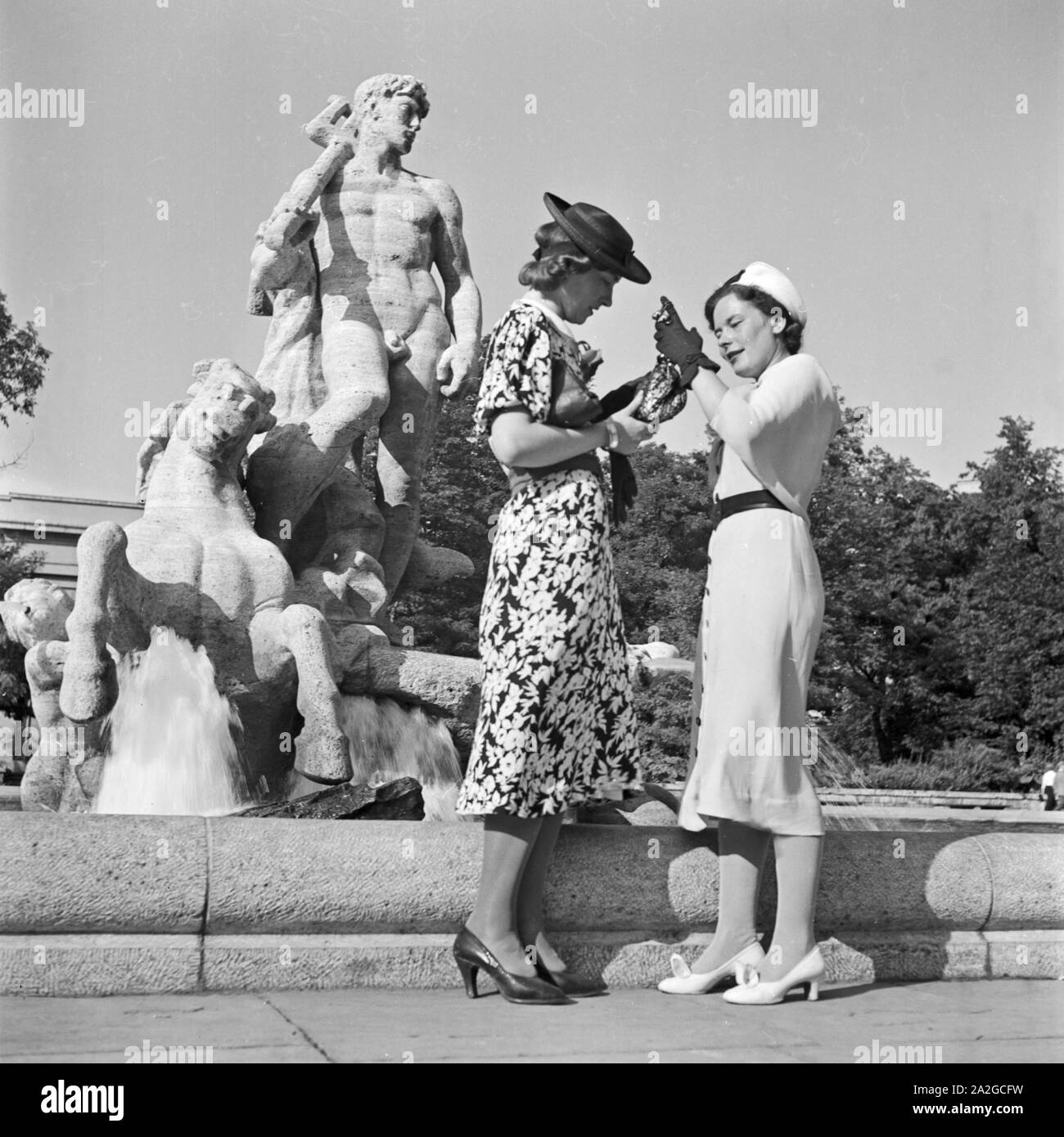 Zwei Frauen vor einer Männerskulptur, Deutschland 1930 er Jahre. Deux femmes par une sculpture de l'homme, de l'Allemagne des années 1930. Banque D'Images