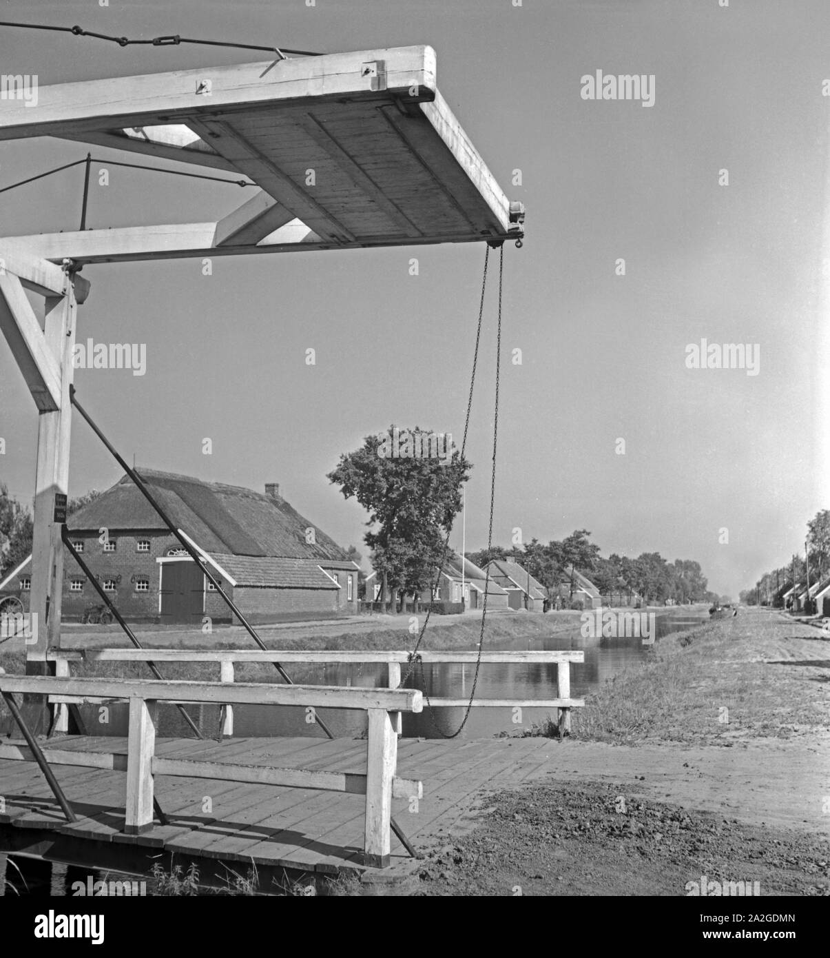 Un Hebebrücke Partie mit einem Kanal en Ostfriesland, Deutschland 1930er Jahre. Impression à un pont de levage en Frise orientale paysage, Allemagne 1930. Banque D'Images