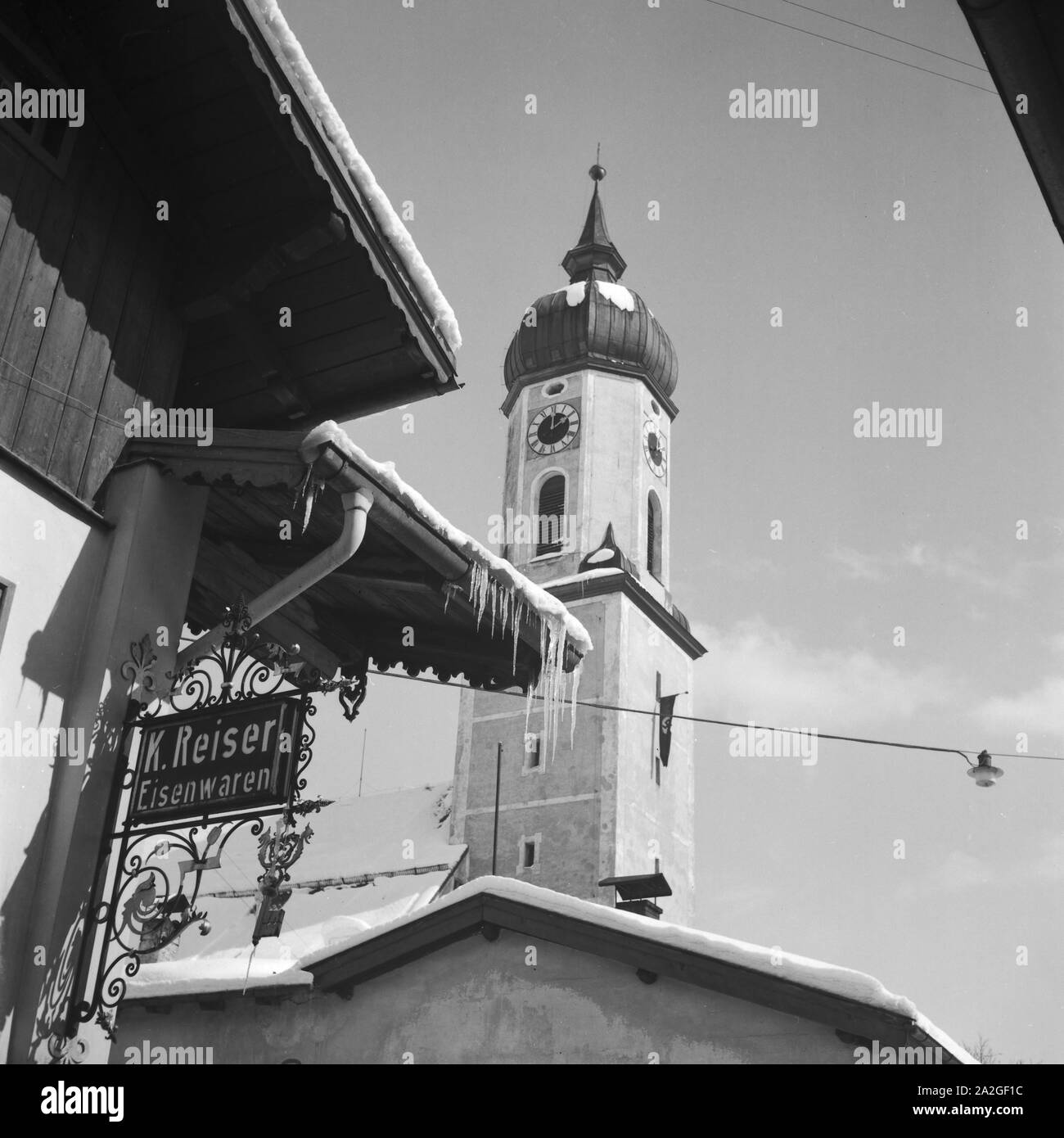 Blick in einen Ortskern mit Kirche und Ladenlokalen, Deutschland 1930 er Jahre. vue d'un centre ville avec beffroi et une pharmacie, Allemagne 1930. Banque D'Images