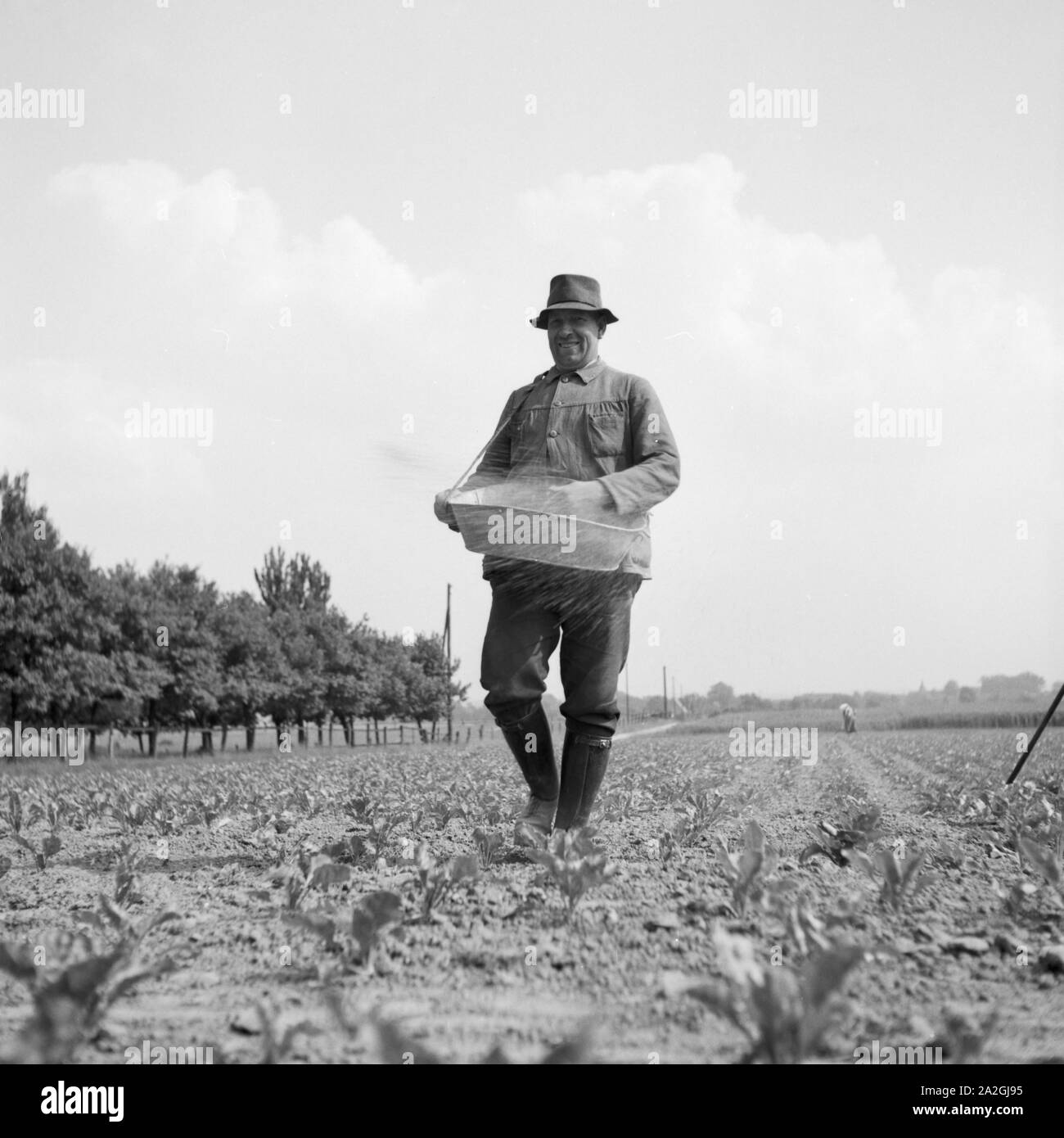 Ein Bauer bringt die Saat auf seinem Acker dans Westfalen aus Deutschland, 1930er Jahre. Un agriculteur de semer son champ à Westfalia, Allemagne 1930. Banque D'Images